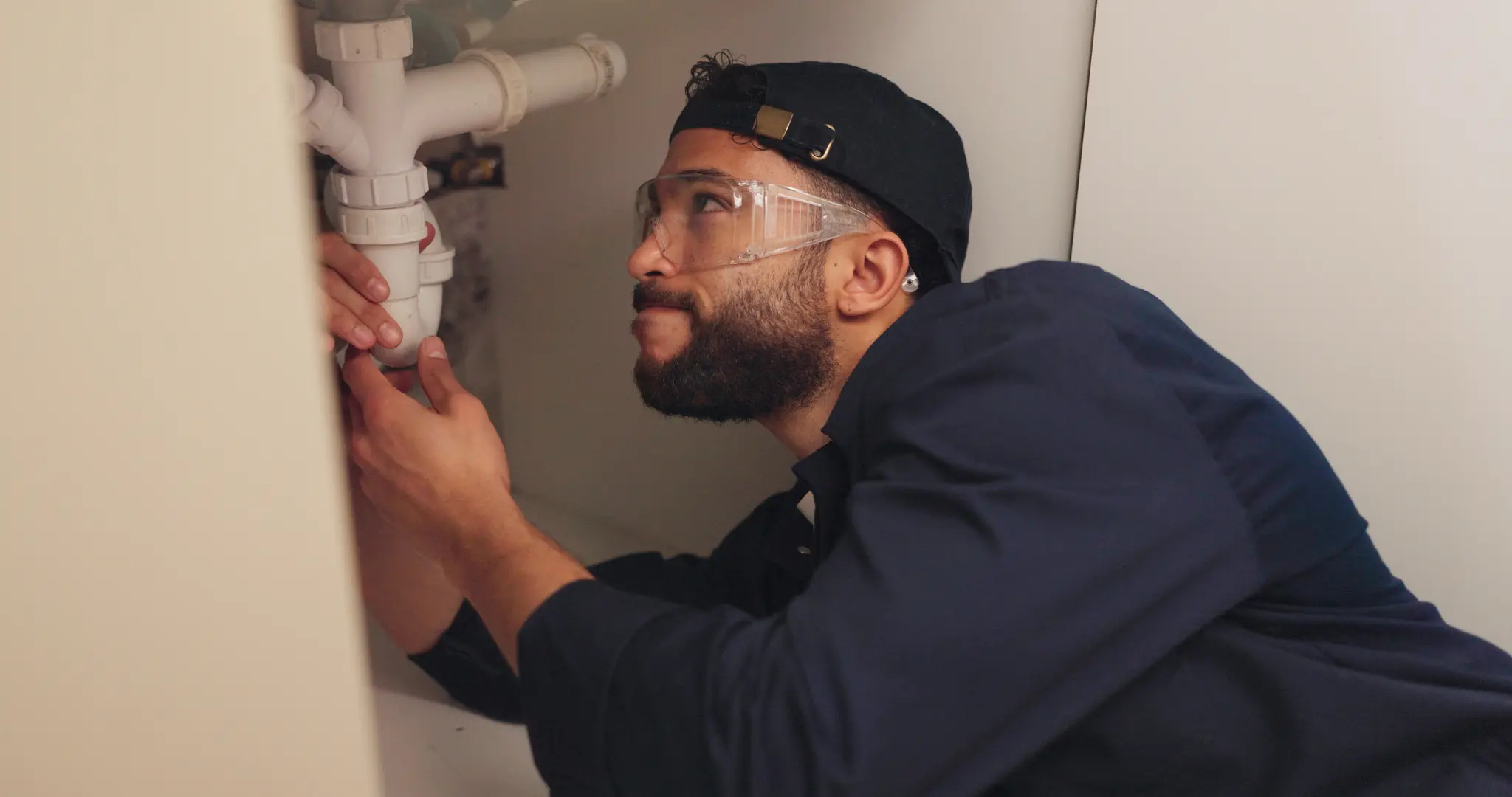 Professional plumber inspecting pipes